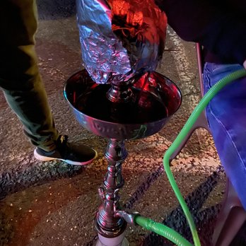 Cafe Ra - a person pouring red liquid into a bowl - Hookah Bars Near Me - Old Bridge, New Jersey