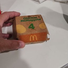 a hand holding a box of food