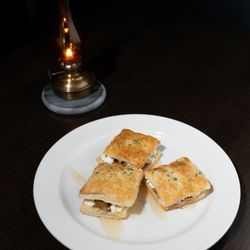 McCollum's On York - Caramelized Onion &
Goat Cheese Bites. Little puff pastry squares topped with
caramelized onions, goat cheese &
honey drizzle.