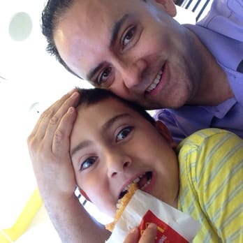 McDonald's - a man and a child eating a hot dog - Fast Food Near Me - Newcastle, Ontario