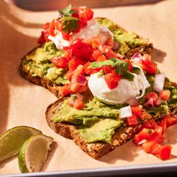 Our fresh made avocado toast with pico de galo, poached eggs and fresh lime wedges.