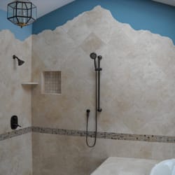 Tile Image Expressions - Travertine shower with custom corner caddy and custom soap niche. Mosaic accent and hand crafted mountain silhouette.