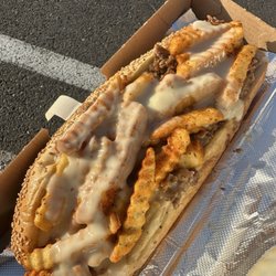 Gritty Cheesesteak - A steak sandwich topped with Old Bay fries and white cheddar cheese sauce.