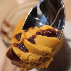 Inka Grill - A spoon holds a spoonful of the Chocolucma dessert with chocolate syrup on top.
