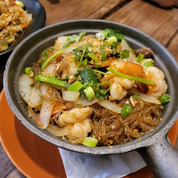 Lime Leaf - a skillet of food on a wooden table - Thai Near Me - Weymouth, Massachusetts
