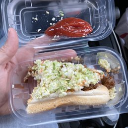 person holding a hot dog with coleslaw and ketchup person holding a hot dog with coleslaw and ketchup