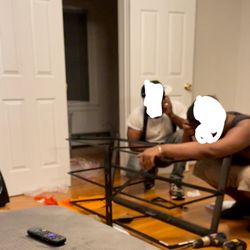 Maddy's Home Furniture & More - Them struggling to install the TV stand (which is not the one we ordered)