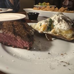 Shared a 12oz New York strip steak and loaded baked Potato. Cooked to perfection again! Shared a 12oz New York strip steak and loaded baked Potato. Cooked to perfection again!