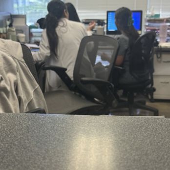 Complete Dermatology - Aiea - Back view:  Natalie, PA in white coat on left and Jasmine on right@computer. - Dermatologists Near Me - Aiea, Hawaii