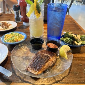 1937 Spirits & Eatery - Blackened salmon plus sorghum butter and cocktail sauce, sides of broccoli almodine and honey creole corn. The Neptune drink next to water. - Cocktail Bars Near Me - Jacksonville, Florida 1937 Spirits & Eatery - Blackened salmon plus sorghum butter and cocktail sauce, sides of broccoli almodine and honey creole corn. The Neptune drink next to water. - Cocktail Bars Near Me - Jacksonville, Florida