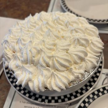 Black Bear Diner Morris - Homemade Banana Cream Pie (400-560 cals.) - Banana cream pie with whipped cream topping served at Black Bear Diner, Morris, IL, on a checkered plate. - Diners Near Me - Morris, Illinois
