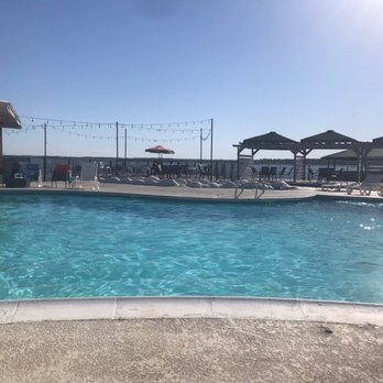 Wave On Lake Conroe - a pool with lounge chairs and umbrellas - Bars Near Me - Willis, Texas