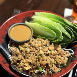 Chicken Lettuce Wraps - A plate of lettuce wraps with ground chicken, sliced cucumber, and a small container of dipping sauce, served at P.F. Chang's in Mesa, AZ.