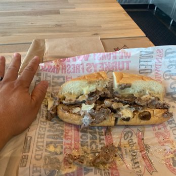 Capriotti's Sandwich Shop - Small Classic Philly Cheesesteak (hand for size reference) - Sandwiches Near Me - Murray, Utah