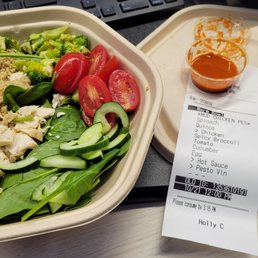 a salad and a receipt on a desk a salad and a receipt on a desk