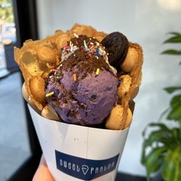 a hand holding a cone of ice cream