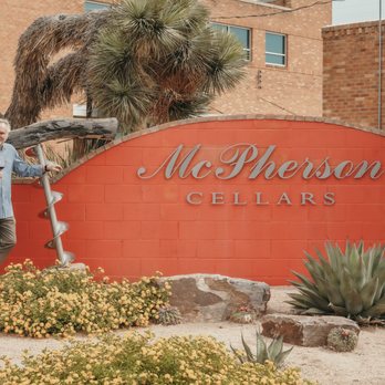 McPherson Cellars - Kim in front of sign - Wineries Near Me - Lubbock, Texas