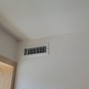 Efficiency Revolution - Installed HVAC went, so we are no longer roasting. - A ceiling vent is positioned near a window in a room with white walls and a wooden window frame. - Insulation Installation Near Me - Golden, Colorado