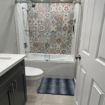 Tam's General Construction - a bathroom with a shower, toilet, and bathtub - General Contractors Near Me