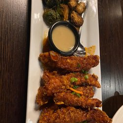 T Bones Great American Eatery - Honey Sriracha Chicken Crunchy corn flake breading, honey-sriracha drizzle, fried Brussels sprout, scallion, sesame dipping sauce.