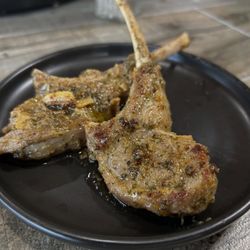 The Cenacle Bistro - Juicy herb-seasoned lamb chops seared to perfection with garlic butter. A rich, flavorful dish perfect for dinner near you.