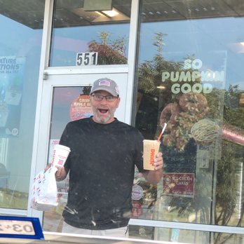 Dunkin' -  a man standing in front of a dunkin donuts shop - Coffee & Tea Near Me - Bastrop, Texas