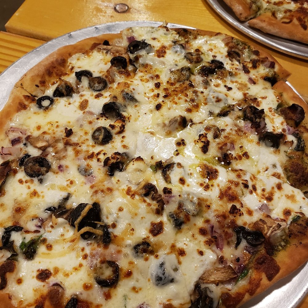 two pizzas on a table two pizzas on a table