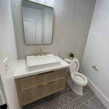 Martinez Construction - a bathroom with a sink, toilet, and mirror - General Contractors Near Me Martinez Construction - a bathroom with a sink, toilet, and mirror - General Contractors Near Me