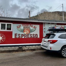 a white car parked in front of a red building
