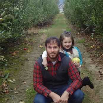 Illuminating Landscapes - a man and a little girl in an apple orchard - Landscaping Near Me - Ladson, South Carolina