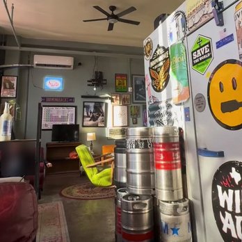 The Loose Screw - Signage, chairs, and sofas in the lounge area toward the back. - Beer Gardens Near Me - Taylor, Texas