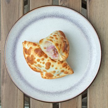 Milonga Empanadas - a piece of pizza on a plate - Empanadas Near Me - San Marcos, California