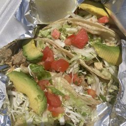 Carnitas and chicken loaded tacos on corn.