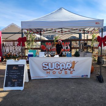 Sugar House - a woman standing behind a sugar house sign - Desserts Near Me Sugar House - a woman standing behind a sugar house sign - Desserts Near Me