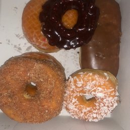 Cinnamon, coconut, original, and chocolate glazed donuts. Cinnamon, coconut, original, and chocolate glazed donuts.