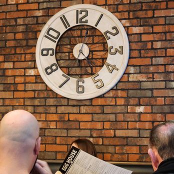 Egg House - a man and a woman sitting in front of a clock - Breakfast & Brunch Near Me - Lombard, Illinois