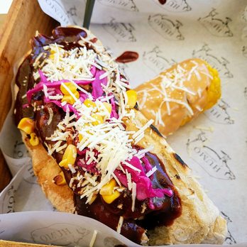 Humo Charcutería - Sausage Sandwich, topped off with BBQ Pulled Pork, Cheese, and Corn, with a side of Corn on the Cob - Food Trucks Near Me - Tijuana, BCN