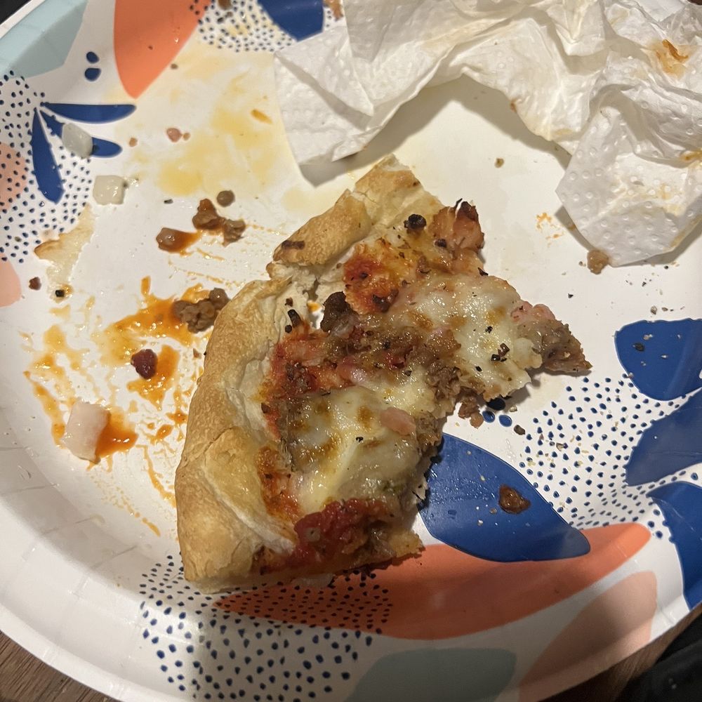 Just Pizza - a half eaten pizza on a paper plate - Pizza Near Me - Indianapolis, Indiana