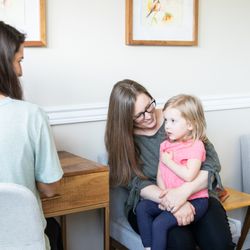 Nourish Osteo and Wellness - Parent and child speaking with an osteopath before treatment.