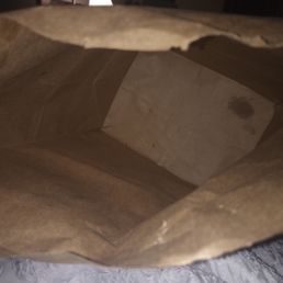 a brown paper bag on a bed a brown paper bag on a bed