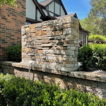 Higher Ground Landscaping - a man sitting on a stone wall - Landscaping Near Me Higher Ground Landscaping - a man sitting on a stone wall - Landscaping Near Me