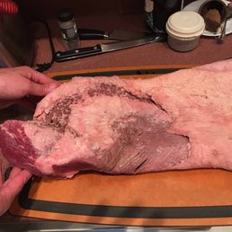 a large piece of meat on a cutting board a large piece of meat on a cutting board