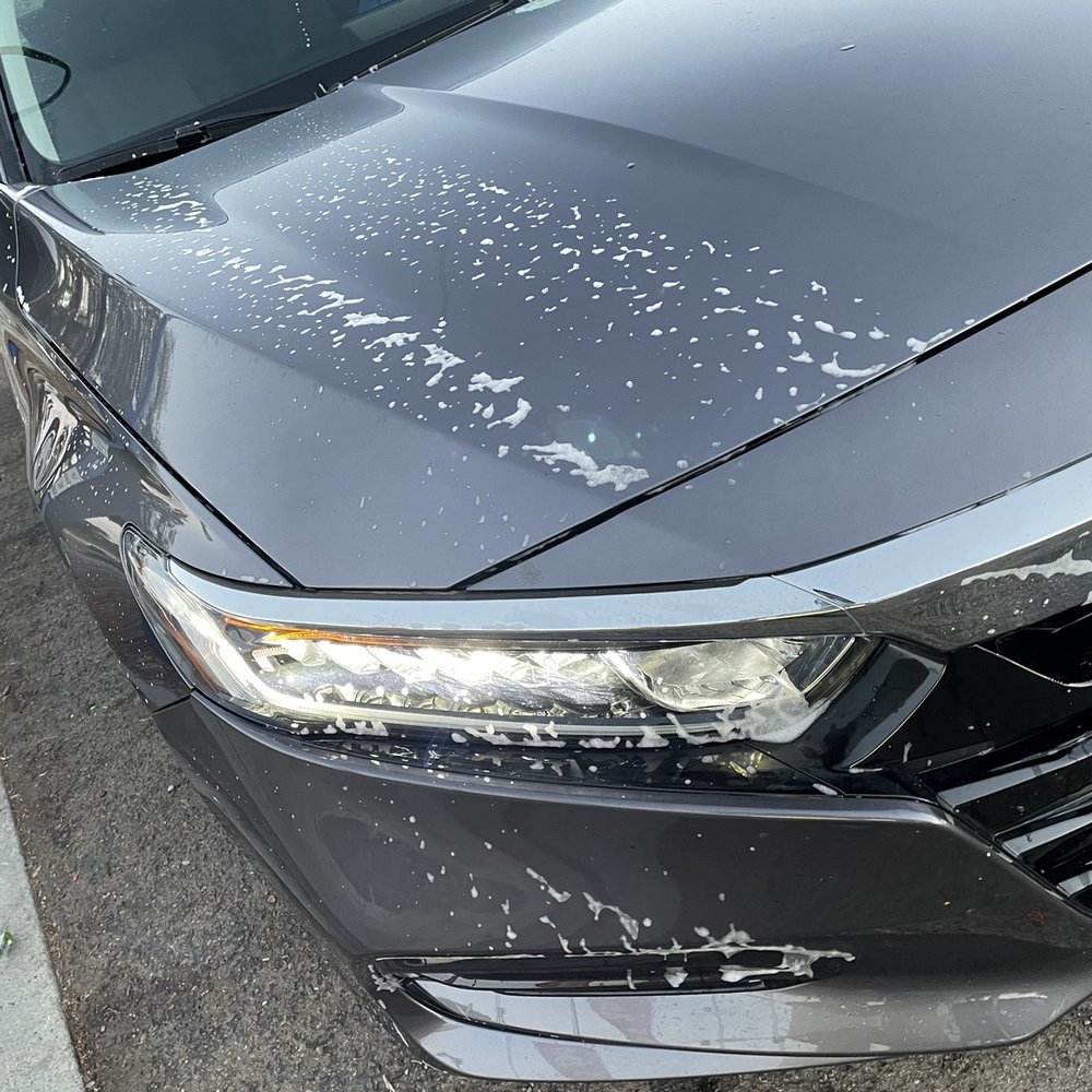 the front of a black car with a lot of paint on it