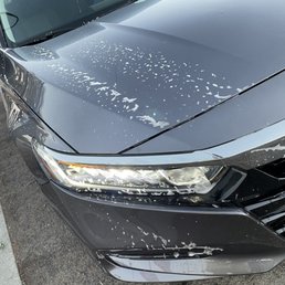the front of a black car with a lot of paint on it the front of a black car with a lot of paint on it