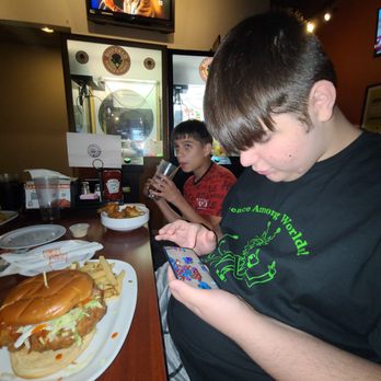 Wings and Rings - 16 year old being 16 year olds!! Put the phone down and dig into this beast of a chicken sandwich!!! He loved it - Chicken Wings Near Me - Grove City, Ohio Wings and Rings - 16 year old being 16 year olds!! Put the phone down and dig into this beast of a chicken sandwich!!! He loved it - Chicken Wings Near Me - Grove City, Ohio