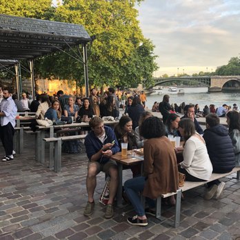 Les Nautes - People on the patio and riverbank enjoying a drink and small snack! - Bars Near Me - Paris, 75