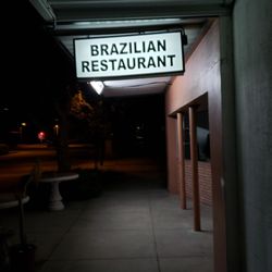 Nighttime shot of the sign over the sidewalk
