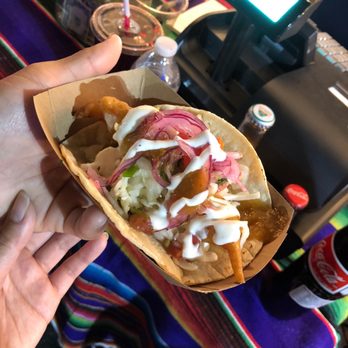 Taco Del Fish - a person holding a taco - Street Vendors Near Me Taco Del Fish - a person holding a taco - Street Vendors Near Me