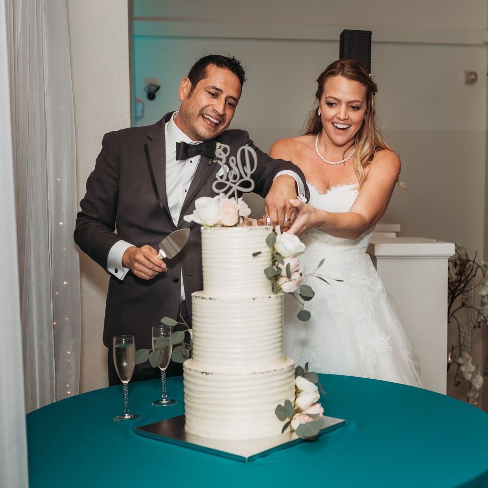 a bride and groom cutting their wedding cake a bride and groom cutting their wedding cake