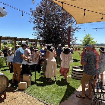 Maragas Winery - a group of people standing around a table with wine barrels - Wineries Near Me - Culver, Oregon